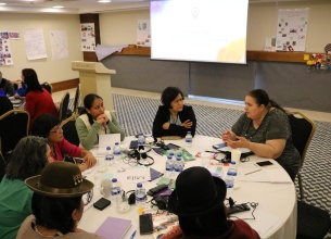 Group of UN Trust Fund grantee organizations representatives sitting around a table during a workshop