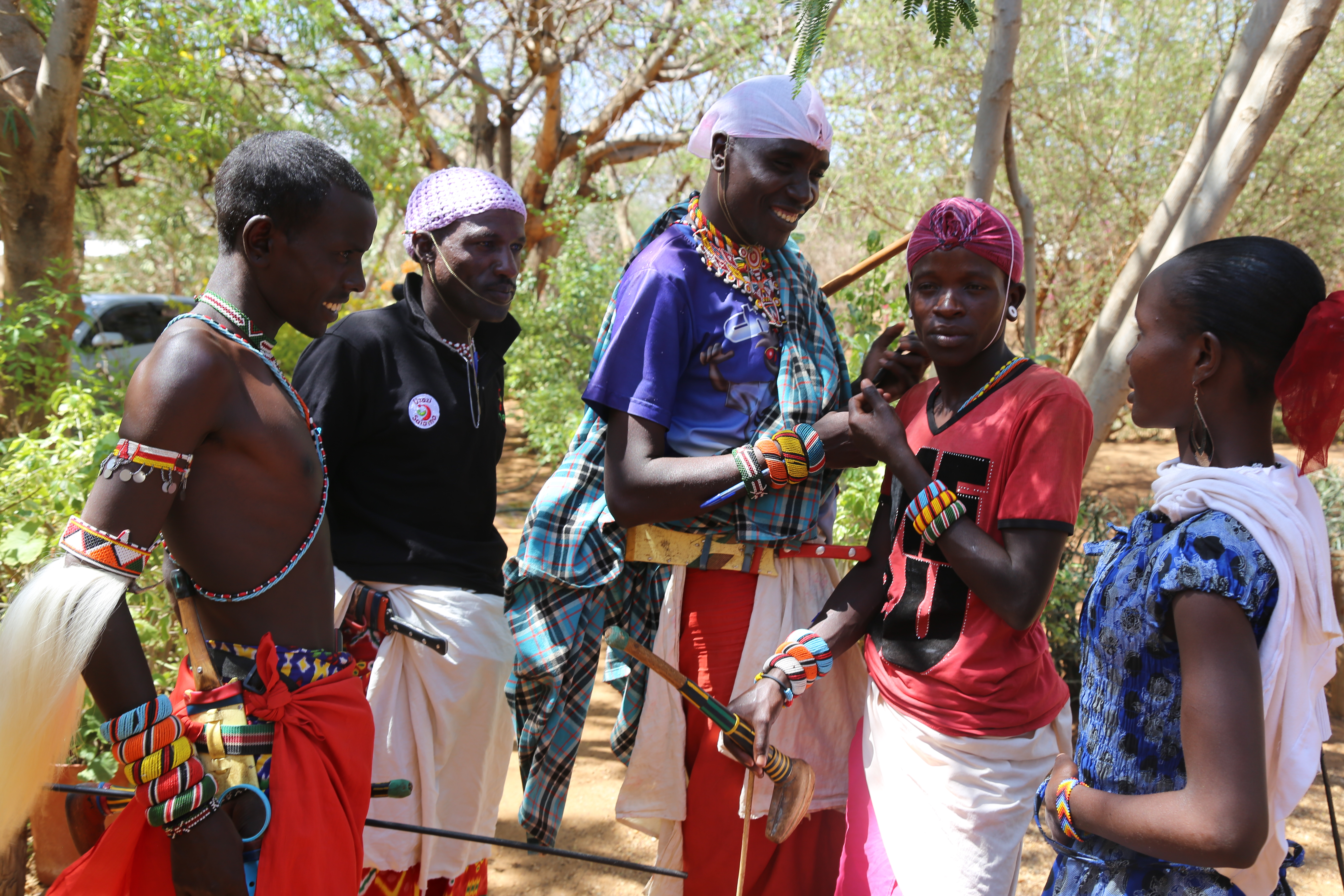 Community youth (Moran's) and a lady having a discussion after a session during community mobilization forum in Wamba (Samburu County).