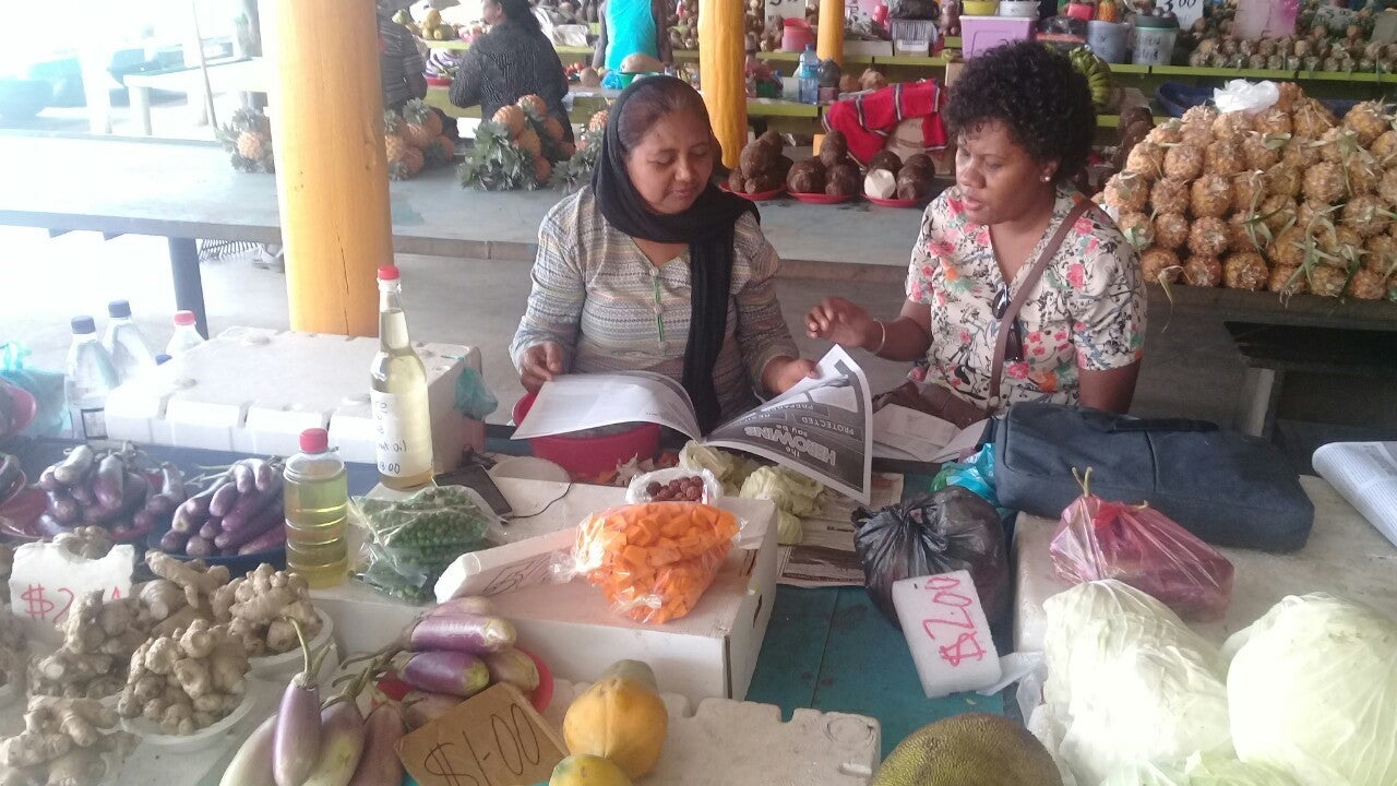 Two women sitting in a marketplace