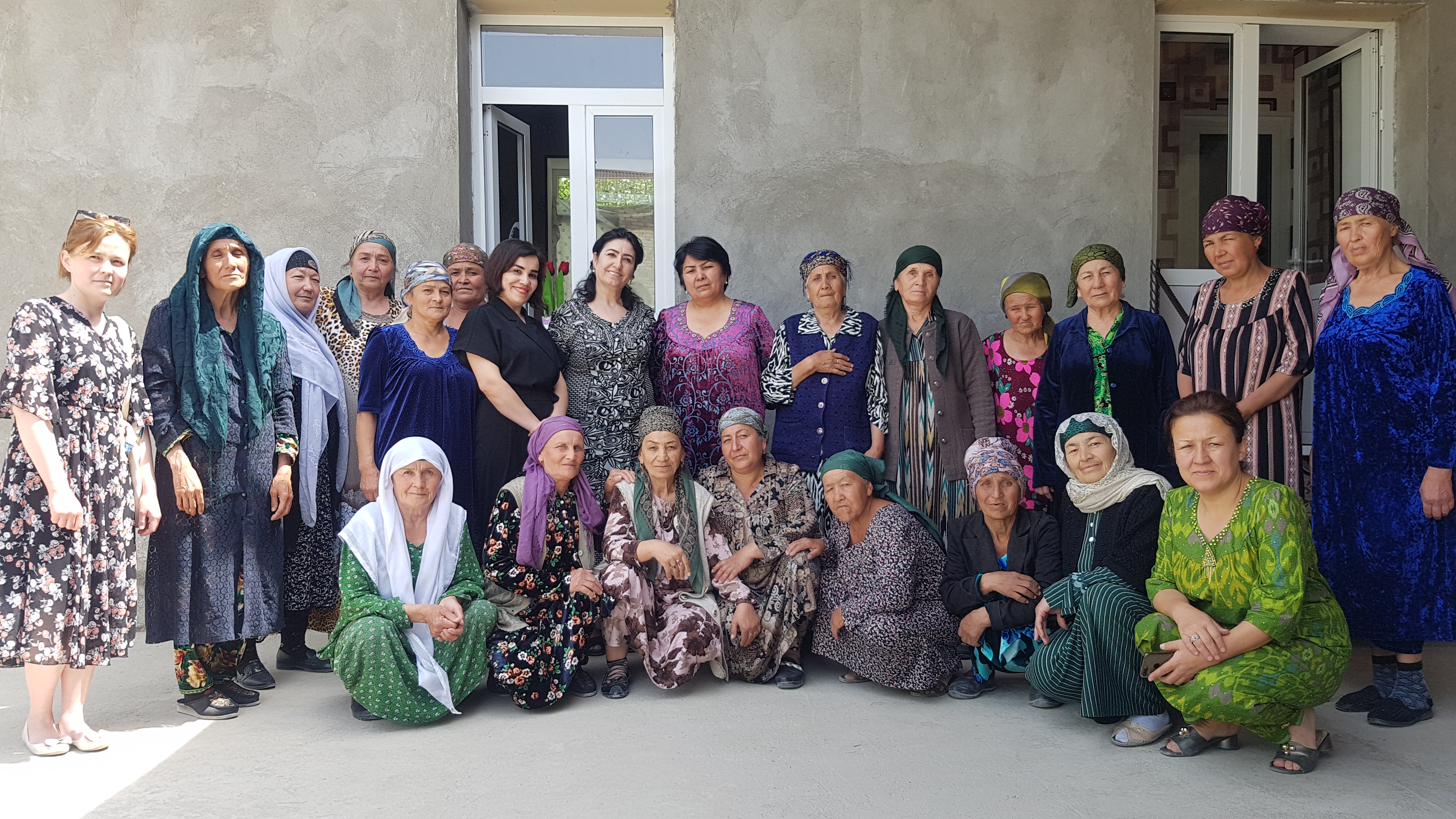 Group of women outside with one row standing up and one row sitting or kneeling down for a group photo