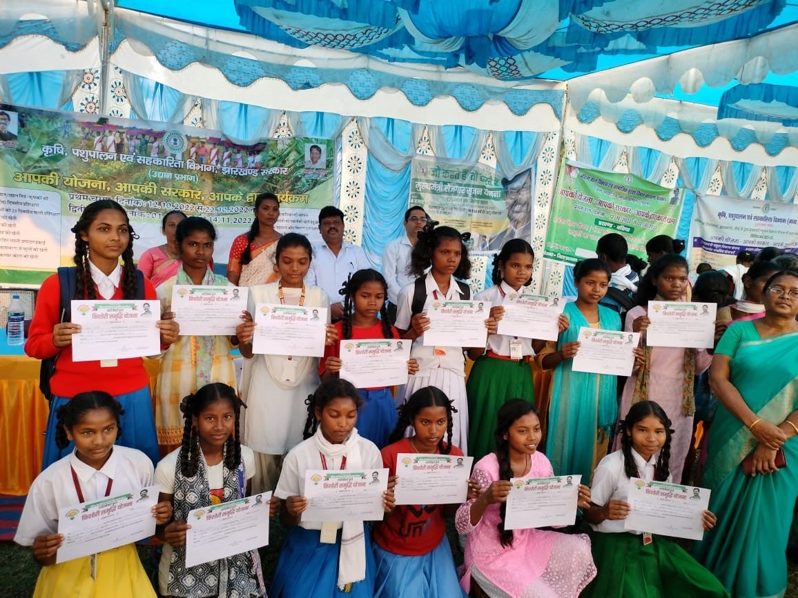 Group of young Indian girls outside posing for a group photo and holding with their hands certificates