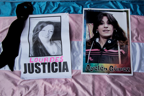 two photos on top of the transgender flag showing the images of transgender women murdered in Argentina as part of the march