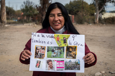 an indigenous woman beneficiary of UN Trust Fund grantee ANDHES holding a sign that reads si a la vida q' tambien es la otra