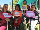 Pictured are four women participants of FUSA, three of them on wheelchairs holding signs that read my life my decision